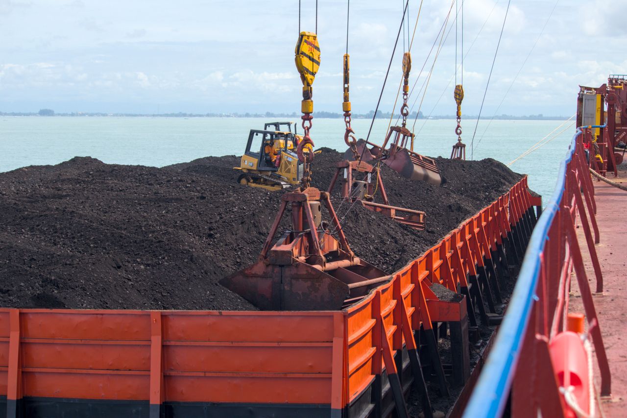Crafting Captivating Headlines: Your awesome post title goes here Heavy machinery loading coal onto a cargo ship at a seaport with cranes.